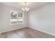 Bright dining area with hardwood floors, a modern chandelier, and a large window overlooking the yard at 608 Woodside Dr., Conway, SC 29526