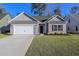 Charming single-story home featuring a two-car garage and a well-manicured lawn, under a clear blue sky at 608 Woodside Dr., Conway, SC 29526