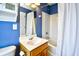 Bright bathroom featuring a vanity, mirror, white shower-tub combo, and white fixtures set against calming blue walls at 6172 Catalina Dr. # 515, North Myrtle Beach, SC 29582