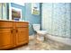 Bathroom with wood vanity, a toilet, tiled floor, and shower showcasing decorative curtain, blending function and style at 6172 Catalina Dr. # 515, North Myrtle Beach, SC 29582