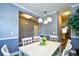 Well-lit dining room showcasing a white dining table, chandelier, wainscoting, and view to the kitchen at 6172 Catalina Dr. # 515, North Myrtle Beach, SC 29582