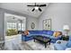 Living room featuring a blue sectional sofa, gray walls, ceiling fan, and view to the sunroom at 6172 Catalina Dr. # 515, North Myrtle Beach, SC 29582
