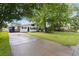 Charming home featuring a well-manicured front yard and a blue front door surrounded by lush, mature trees at 6304 Timberline Dr. # B, Myrtle Beach, SC 29572