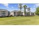 Exterior view of multi-story condo buildings featuring balconies and manicured lawn in a golf course community at 633 Waterway Village Blvd # 11D, Myrtle Beach, SC 29579