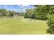 Scenic view of golfers on a lush green golf course with clubhouse in the background on a sunny day at 633 Waterway Village Blvd # 11D, Myrtle Beach, SC 29579