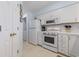 Well-lit kitchen with white cabinets, appliances, and adjacent laundry area at 633 Waterway Village Blvd # 11D, Myrtle Beach, SC 29579