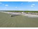 Aerial view showcasing the beach and pier near a neighborhood, highlighting coastal living at its finest at 691 Sandberg St., Surfside Beach, SC 29575