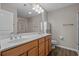 Bathroom featuring double sinks, wood cabinets, tile floor, and updated lighting at 691 Sandberg St., Surfside Beach, SC 29575