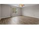 Spacious bedroom features wood flooring, a ceiling fan, and a window overlooking the backyard at 691 Sandberg St., Surfside Beach, SC 29575