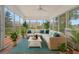 Bright sunroom with large windows, comfortable seating, ceiling fan, and view of the backyard and neighborhood at 691 Sandberg St., Surfside Beach, SC 29575