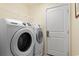 Laundry room featuring a modern washer and dryer, with a white door and wire shelving at 696 Rambler Ct., Myrtle Beach, SC 29588