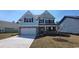 Charming two-story home with stone accents, blue siding, a front lawn, and an attached two-car garage at 756 Choctaw Dr., Conway, SC 29526