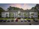 Exterior of a bright condo building with parking, manicured lawn, and lush landscaping at 760 Charter Dr. # D-4, Longs, SC 29568