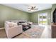 Bright living room with a comfortable sectional sofa, stylish rug, ceiling fan, and sliding glass doors to the backyard at 787 Dusty Pine Way, Myrtle Beach, SC 29588