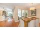 Dining room with wood floors and walls of glass leading to the sunroom and living room at 8 Martinique Dr., Myrtle Beach, SC 29572