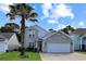 Charming two-story home with a well-maintained lawn, brick facade, and a beautiful palm tree in the front yard at 867 Cardinal Pl., North Myrtle Beach, SC 29582