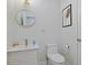 Neat half bathroom featuring modern fixtures, a round mirror, and a decorative wall hanging at 867 Cardinal Pl., North Myrtle Beach, SC 29582