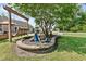 Landscaped backyard featuring a swing bench, decorative accents, and a large tree providing shade at 901 Southwind Ct., Garden City Beach, SC 29576