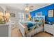 Cozy bedroom with bright blue accent wall, beach-themed decor, and tile flooring at 901 Southwind Ct., Garden City Beach, SC 29576