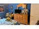 Bedroom features wood dresser with mirror, desk, TV and colorful wall decor at 901 Southwind Ct., Garden City Beach, SC 29576