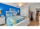 Bedroom with bright blue accent wall, beach-themed decor, and white wood flooring at 901 Southwind Ct., Garden City Beach, SC 29576