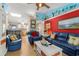 Comfortable living room with blue furniture, a coastal mural, tile floors, and an open layout with barstool seating at 901 Southwind Ct., Garden City Beach, SC 29576