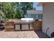 Modern outdoor kitchen with stainless steel grill, stone surround, and countertop sink for entertainment at 901 Southwind Ct., Garden City Beach, SC 29576