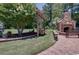 Backyard with stone fireplace, swing, and lush landscaping, creating a serene outdoor retreat at 901 Southwind Ct., Garden City Beach, SC 29576