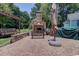 Outdoor fireplace with seating, an umbrella, and a swing set create an inviting backyard at 901 Southwind Ct., Garden City Beach, SC 29576