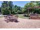 Relaxing patio with a swing, table, and chairs surrounded by a lush lawn with mature trees at 901 Southwind Ct., Garden City Beach, SC 29576