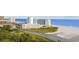 Overhead view of an oceanfront condo complex by a river, featuring a sandy beach and blue ocean water at 9400 Shore Dr. # 509, Myrtle Beach, SC 29572