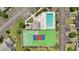 Aerial view of a community's tennis court and pool area, showcasing recreational amenities amidst well-kept landscaping and parking at 951 Plantation Dr. # F8, Little River, SC 29566