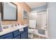 Bright bathroom featuring wood accent wall, framed mirror, blue vanity, and shower with sliding glass doors at 1053 Williston Loop # 1053, Murrells Inlet, SC 29576