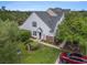 Aerial view of the home's exterior elevation, green lawn, mature trees, and driveway with parked cars at 1053 Williston Loop # 1053, Murrells Inlet, SC 29576