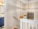 Well-lit hallway featuring wood stairs, white railing, a decorative pendant light, and an adjacent bathroom at 1053 Williston Loop # 1053, Murrells Inlet, SC 29576
