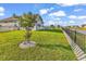 Well-maintained backyard featuring a black fence, small tree, and lush green grass near a serene body of water at 1124 Valetto Loop, Myrtle Beach, SC 29579
