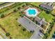 Aerial view of community pool with ample lounge seating, a clubhouse, parking, and manicured landscaping at 1124 Valetto Loop, Myrtle Beach, SC 29579