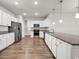 Modern kitchen features white cabinets, granite countertops, stainless steel appliances and wood flooring at 1124 Valetto Loop, Myrtle Beach, SC 29579