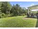 Spacious backyard with green grass, fence, rocking chairs, and lush landscaping at 1146 Joywood Dr., Longs, SC 29568