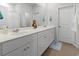 Bright bathroom featuring double sinks, white cabinetry, and a large mirror at 1146 Joywood Dr., Longs, SC 29568