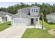 Charming two-story home featuring a well-maintained lawn, a two-car garage, and a mix of modern architectural design elements at 1146 Joywood Dr., Longs, SC 29568