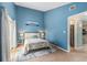Bright bedroom with blue walls, beach themed decor, and a view of an open doorway to another room at 1206 Erin Way # A, Myrtle Beach, SC 29577