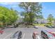 Exterior view of condos near a parking lot surrounded by mature trees and manicured grounds under a clear blue sky at 1206 Erin Way # A, Myrtle Beach, SC 29577
