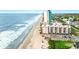 Aerial view features a wide sandy beach and a condominium community near the ocean at 1310 N Waccamaw Dr. # 204, Garden City Beach, SC 29576
