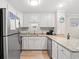 Well-lit kitchen featuring white cabinets, stainless steel appliances and granite countertops at 1310 N Waccamaw Dr. # 204, Garden City Beach, SC 29576