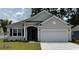 Charming single-story home with a two-car garage and well-manicured lawn, showcasing curb appeal at 157 Stride Ct., Myrtle Beach, SC 29588