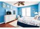 Bright bedroom with blue walls, a ceiling fan, wood floors, and coastal-themed decor at 163 Cypress Ave., Murrells Inlet, SC 29576
