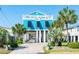 Beautiful raised beach house with blue siding, white pillars, a front deck, and lush palm trees at 163 Cypress Ave., Murrells Inlet, SC 29576