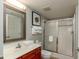 Bright bathroom features a shower with sliding glass doors and a wooden vanity at 1903 S Ocean Blvd. S # 808, North Myrtle Beach, SC 29582