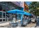 Outdoor seating area with blue umbrellas and tables outside a candy and dessert shop at 1903 S Ocean Blvd. S # 808, North Myrtle Beach, SC 29582
